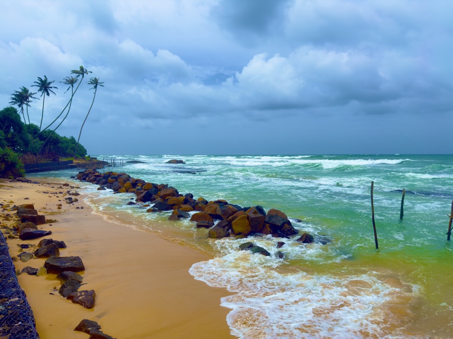Golden sand beach meeting gentle tropical ocean waves in Sri Lanka